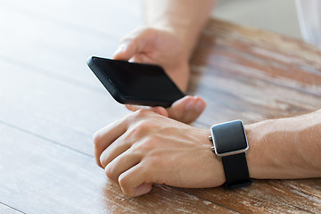 Image showing close up of hands with smart phone and watch