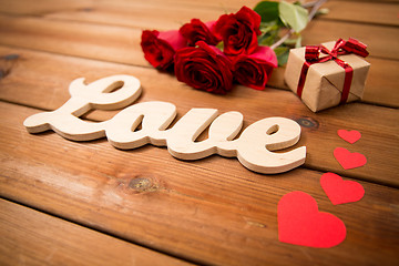 Image showing close up of gift, word love, red roses and hearts