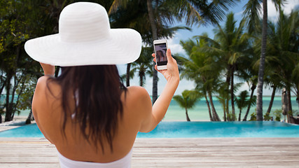 Image showing woman taking selfie with smartphone on beach