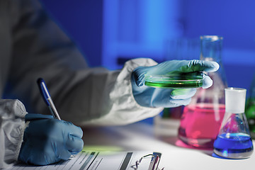 Image showing close up of scientist writing test results in lab