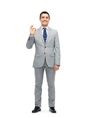 Image showing happy businessman in suit showing ok hand sign