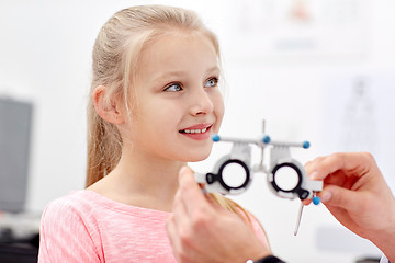 Image showing optician with trial frame and girl at clinic