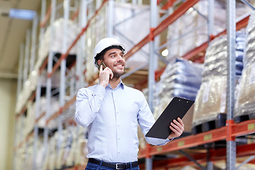 Image showing man with clipboard and smartphone at warehouse