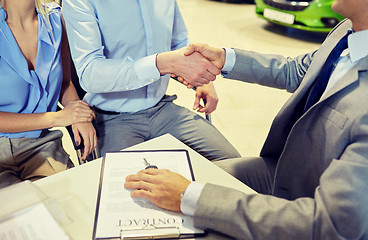 Image showing handshake of customer and car dealer in auto salon