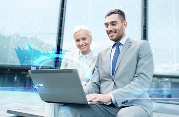 Image showing smiling businesspeople with laptop outdoors