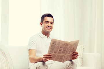 Image showing happy man reading newspaper at home