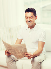 Image showing happy man reading newspaper at home