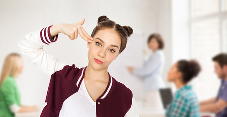 Image showing bored student girl making finger gun gesture