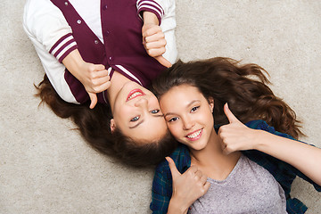 Image showing smiling teenage girls on floor showing thumbs up