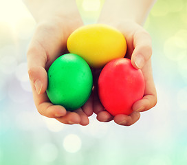 Image showing close up of kid hands holding colored eggs