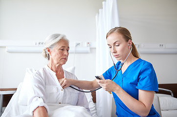 Image showing nurse with stethoscope and senior woman at clinic