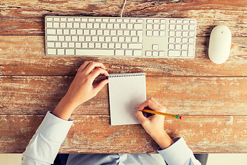 Image showing close up of hands with notebook and keyboard