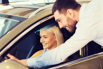 Image showing happy couple buying car in auto show or salon