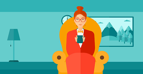 Image showing Woman sitting in chair with cup of tea.