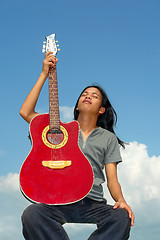 Image showing Asian guitar player taking break