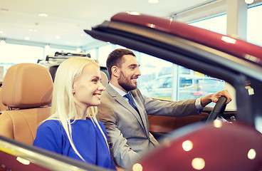 Image showing happy couple sitting in car at auto show or salon