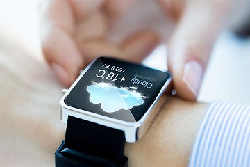 Image showing close up of hands with weather icon on smartwatch