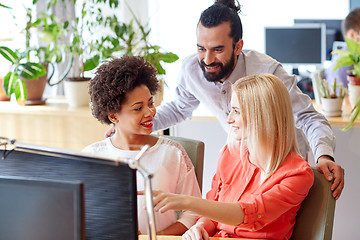 Image showing happy creative team with computer in office