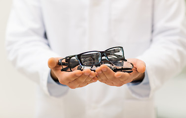 Image showing close up of optician with glasses at optics store