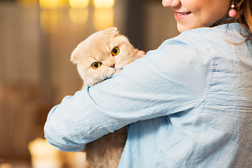 Image showing happy woman holding scottish fold cat at home