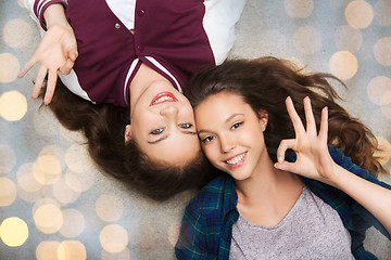 Image showing happy smiling pretty teenage girls lying on floor