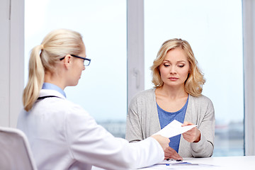 Image showing doctor giving prescription to woman at hospital