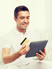 Image showing smiling man working with tablet pc at home