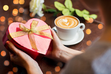 Image showing close up of hands holding heart shaped gift box