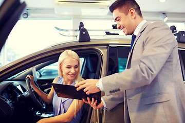 Image showing happy woman with car dealer in auto show or salon