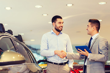 Image showing happy man shaking hands in auto show or salon