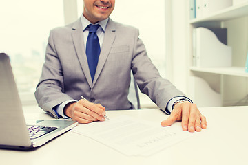 Image showing close up of businessman with laptop and papers