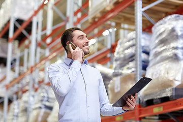 Image showing man with clipboard and smartphone at warehouse