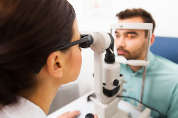 Image showing optician with slit lamp and patient at eye clinic