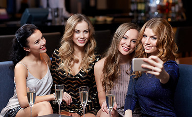 Image showing women with champagne taking selfie at night club