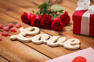 Image showing close up of gift box, red roses and greeting card