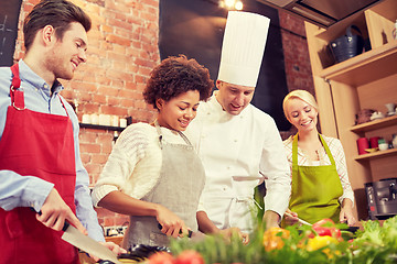 Image showing happy friends and chef cook cooking in kitchen