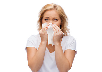 Image showing unhappy woman with paper napkin blowing nose