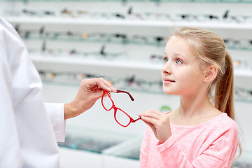 Image showing optician giving glasses to girl at optics store