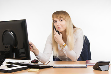 Image showing  Business woman working on the computer, talking on the phone and looked at the frame