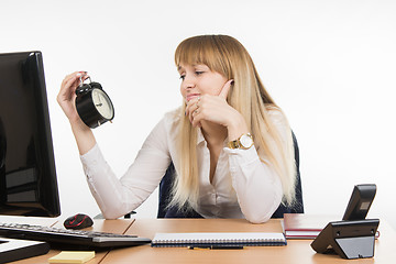 Image showing Office employee sadly looks at the clock with time nine oclock five minutes in the morning