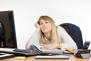 Image showing Office work tired a specialist to sort out folders with documents and looked sadly at the monitor screen