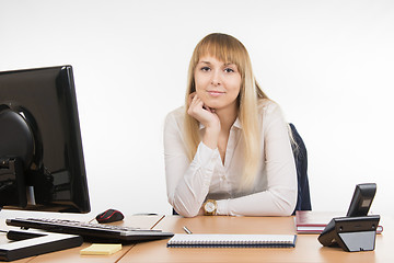 Image showing Business woman sitting at a desk in the office and looking at the frame
