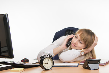 Image showing Not enough sleep office employee at his desk answers the phone