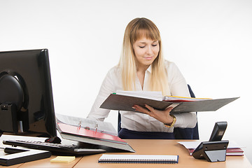 Image showing Tired secretary found the right document in a folder and smiling