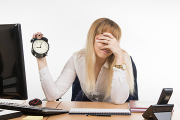 Image showing Office employee covered her face with his hand from the unwillingness to work