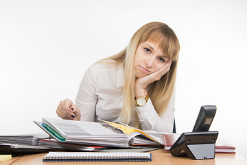 Image showing Tired office leafing through a specialist documents in the folder and looked into the frame