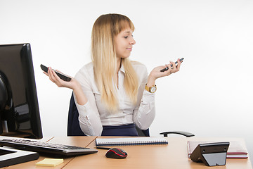 Image showing Secretary holding two phone rang and looked at mobile