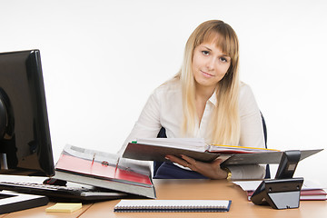 Image showing Office a specialist wearily leafing through a folder with documents