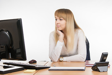 Image showing Business woman looking at a computer monitor at the table in the office