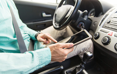 Image showing close up of young man with tablet pc driving car